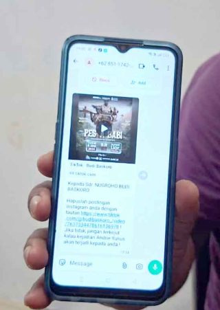 Foto jurnalis Mongabay Budi Baskoro sedang menggunakan telepon genggam di Pangkalan Bun, Kalimantan Tengah.