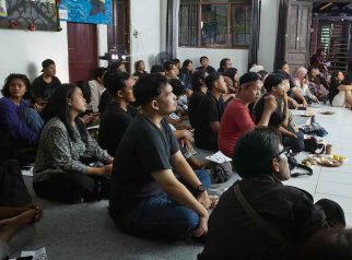Foto penonton menyaksikan nobar film Pesta Babi hingga memenuhi ruangan dan sebagian melihat dari balik kaca jendela di Palangka Raya.