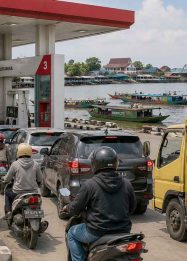 Ilustrasi SPBU di Palangka Raya dengan papan harga BBM, antrean kendaraan, truk distribusi sembako, serta sungai dan klotok di latar belakang.