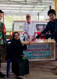 Foto Kepala Desa Palingkau Jaya sedang menyalurkan BLT kepada warga di Kantor Desa Palingkau Jaya.