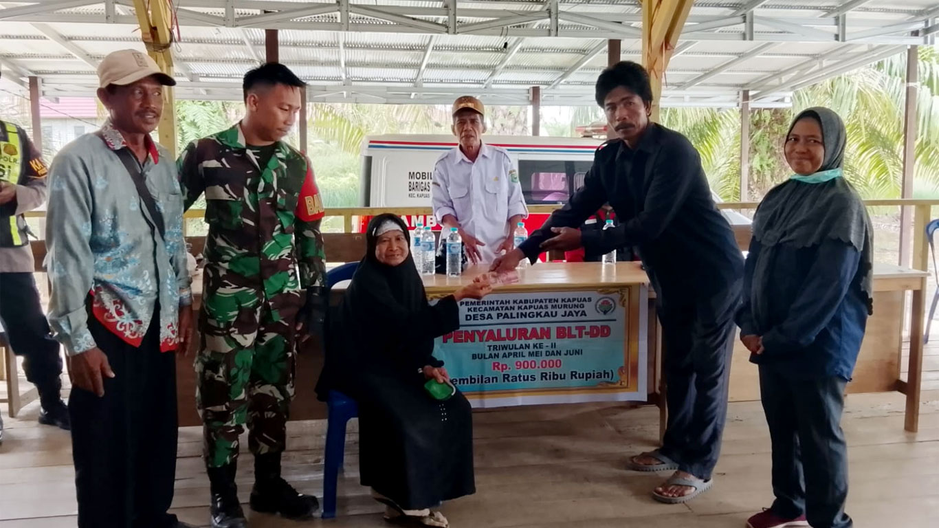 Foto Kepala Desa Palingkau Jaya sedang menyalurkan BLT kepada warga di Kantor Desa Palingkau Jaya.