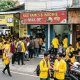 Suasana deretan UMKM di sekitar kampus yang ramai mahasiswa, terlihat warung makan, jasa fotokopi, laundry, dan kedai kopi dipenuhi pelanggan pada jam aktivitas kuliah.