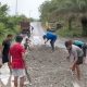 Foto warga sedang menimbun ruas jalan nasional yang rusak parah di Kalimantan Tengah.