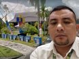 Freddy Simamora dengan latar Kantor PLN Palangka Raya dengan latar gedung PLN.
