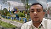 Freddy Simamora dengan latar Kantor PLN Palangka Raya dengan latar gedung PLN.