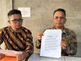 Parlin Bayu Hutabarat didampingi Kandoni Siringoringo menunjukkan teks postingan yang dipersoalkan.