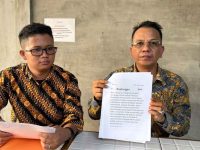 Parlin Bayu Hutabarat didampingi Kandoni Siringoringo menunjukkan teks postingan yang dipersoalkan.