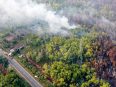 Foto udara kebakaran hutan dan lahan di kawasan yang berbatasan antara Kelurahan Kameloh Baru dan Desa Tumbang Nusa, dengan kepulan asap terlihat di sekitar lokasi.