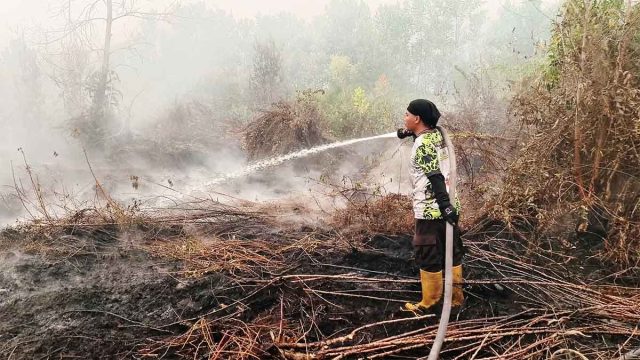BPK Swakarsa Putra Pahandut memadamkan kebakaran lahan yang mendekati permukiman warga di Jalan Sinar Kahayan, Kereng Bangkirai, Palangka Raya