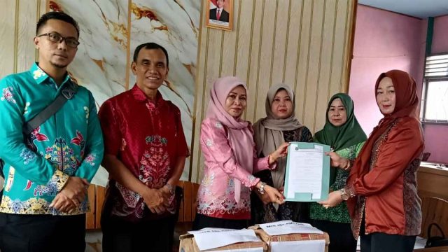 Penyerahan administrasi peminjaman buku antara Disarpustaka Kabupaten Kapuas dan MIS Islamiyah.
