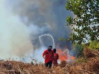 Relawan mengenakan pakaian lapangan berjibaku memadamkan kebakaran lahan gambut di tengah kabut asap