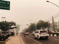 Suasana Kota Palangka Raya diselimuti kabut asap tebal dengan langit berwarna kemerahan akibat kebakaran lahan gambut.