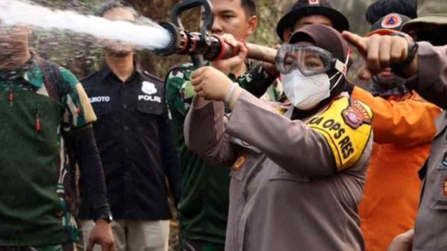 Kapolres Kapuas AKBP Rina Perwitasari memegang nozzle dan ikut secara simbolis dalam pemadaman api karhutla.